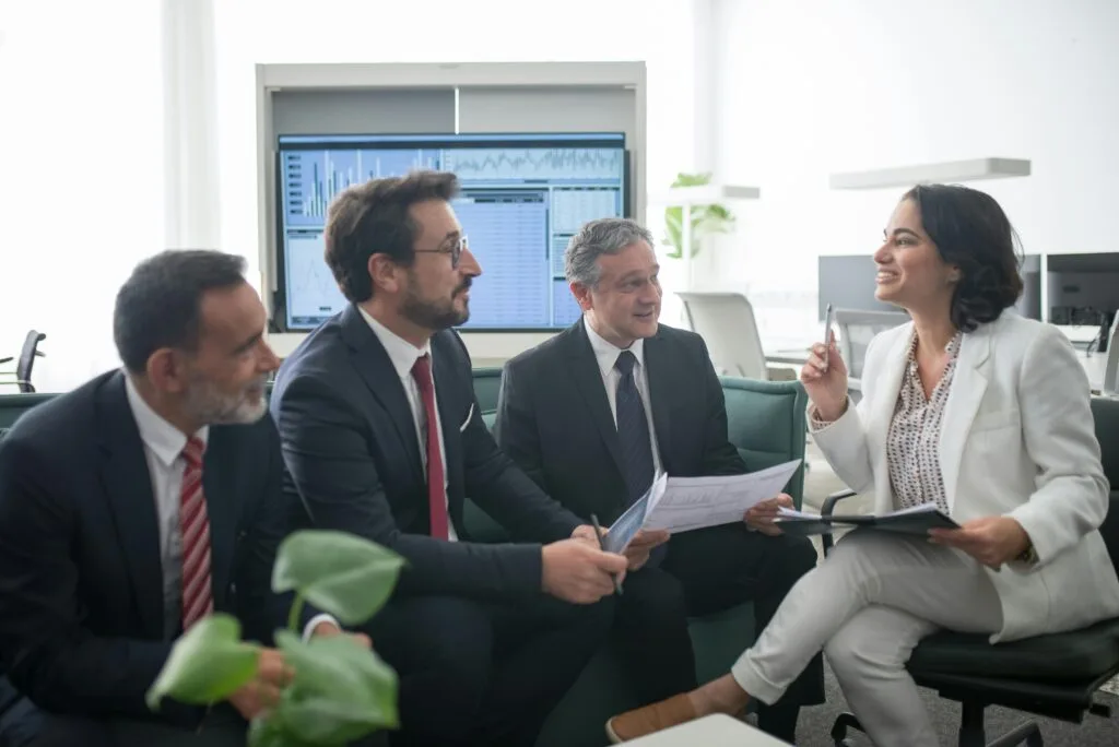 Diverse business professionals engaged in a lively office meeting, fostering collaboration and teamwork.
